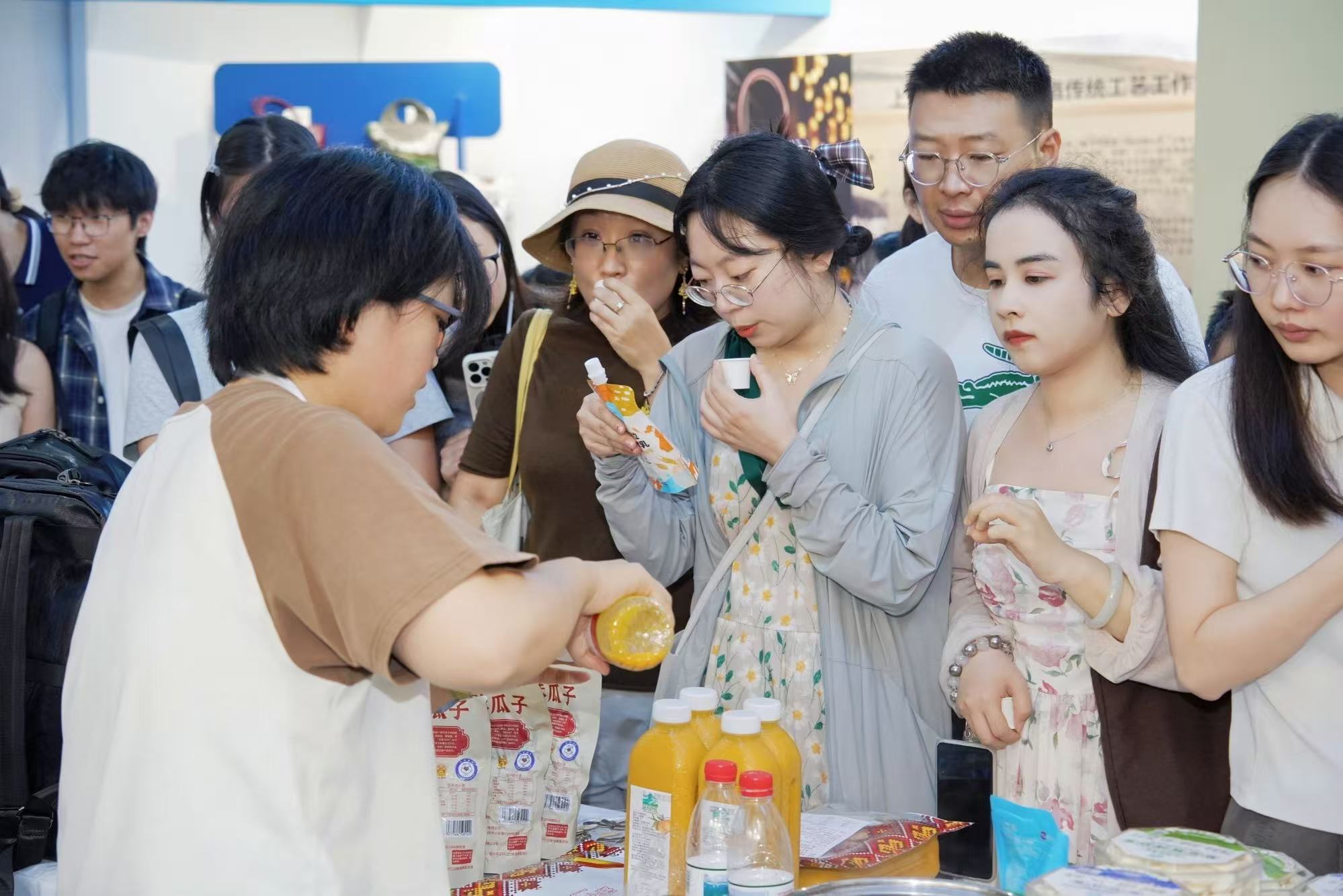 参展工作人员为现场游客提供农特产品试吃体验，大家近距离品鉴来自天山绿洲的兵团风味。.jpg