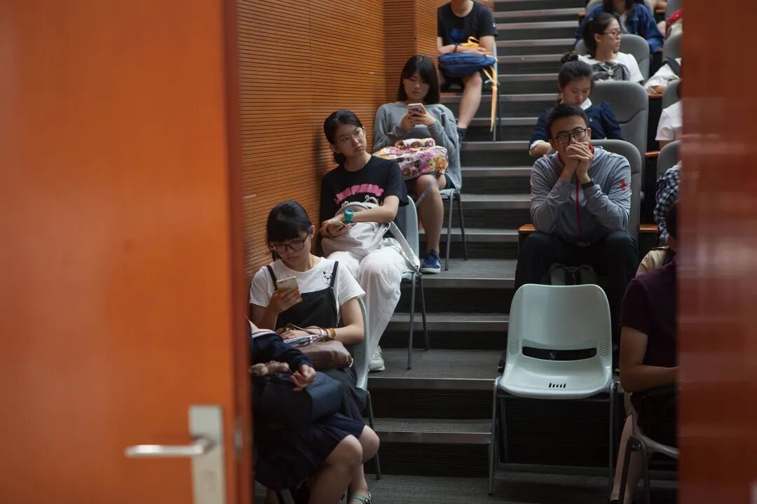 香港汉文大学（深圳）轮廓测评锤真金不怕火罗致线下会聚机考步地。科场外，考生们在使命主谈主员诱导下候考。（图 /CFP）
