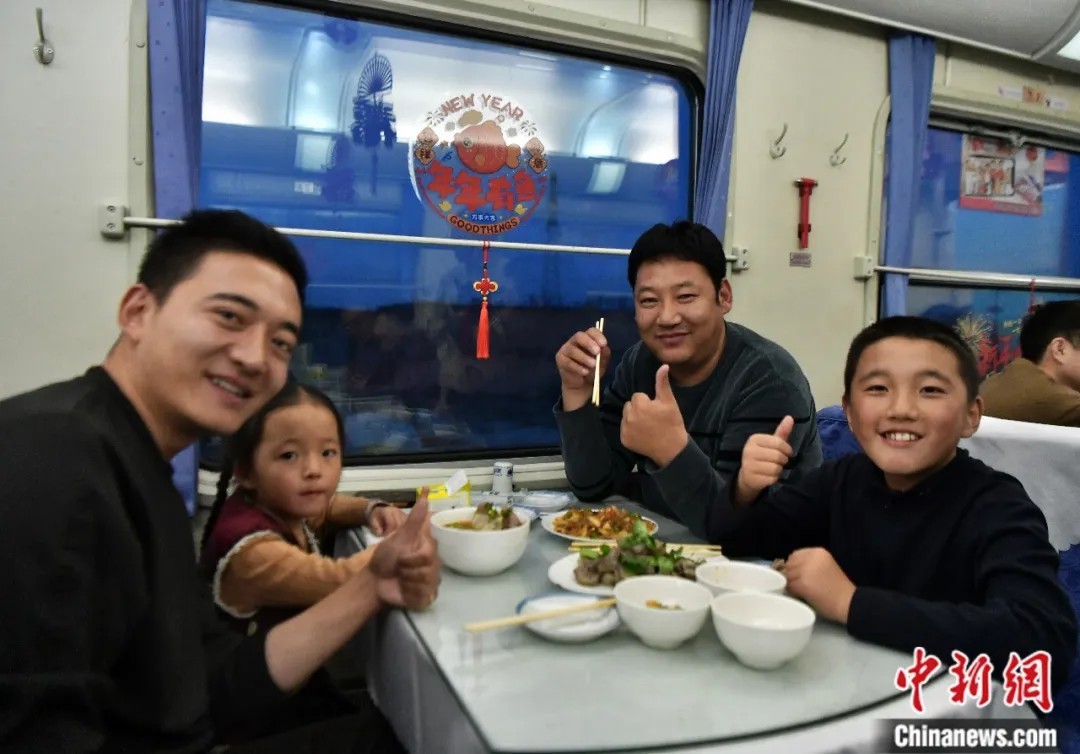 2026年2月5日，北京西开往西宁的T175次列车上，青海旅客更桑(右二)与家人们在餐车品尝手抓羊肉、青海尕面片等西北特色美食。 中新社记者 翟羽佳 摄