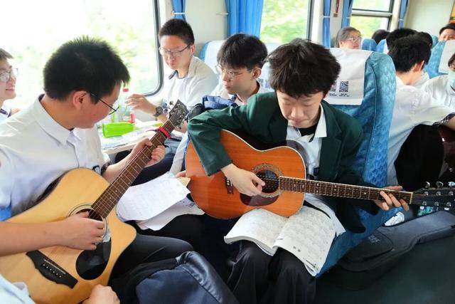 学生在火车上弹吉他。图源：九派新闻