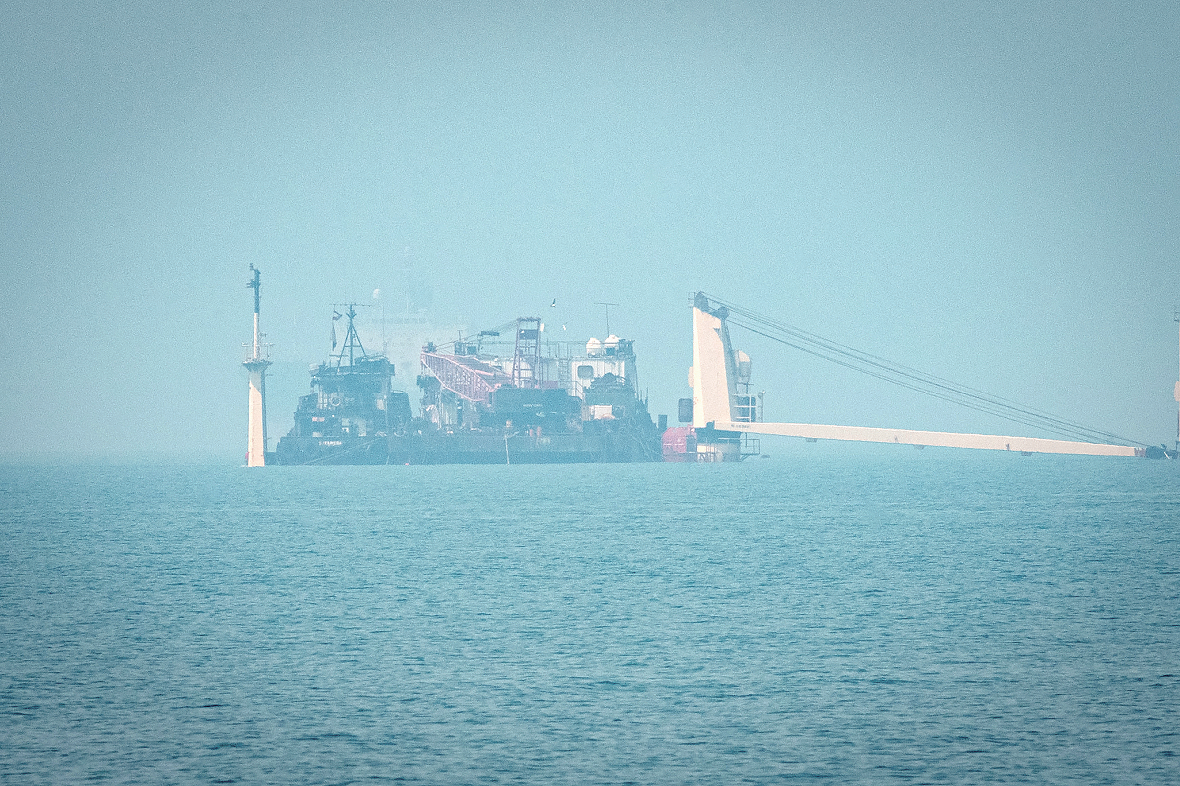 8日，伊朗阿巴斯港附近海域，一艘部分沉没的货轮漂浮在海面上。（视觉中国）