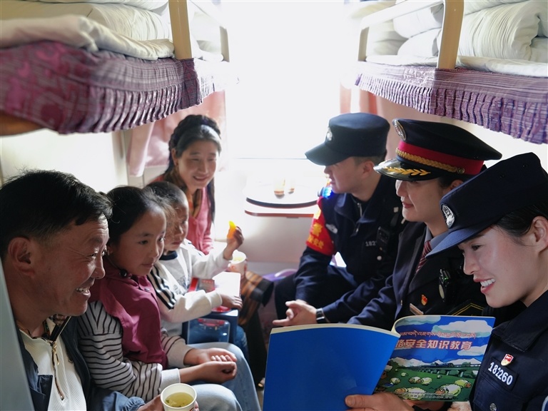 图为在拉萨开往上海的列车上，列车员和铁路警察向旅客科普铁路安全知识。记者 康洁白姆 摄