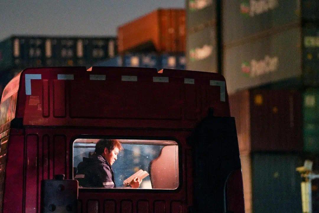 在浙江省宁波市北仑区，集卡司机陈浩利用装卸货间隙专注阅读，这位扎根港城的“新宁波人”，7年间将驾驶室打造成“移动书屋”，5年累计读书400余本。章勇涛摄（影像中国）