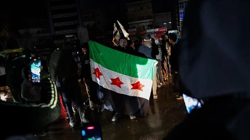 ◆人们在拉卡高举叙利亚新国旗。