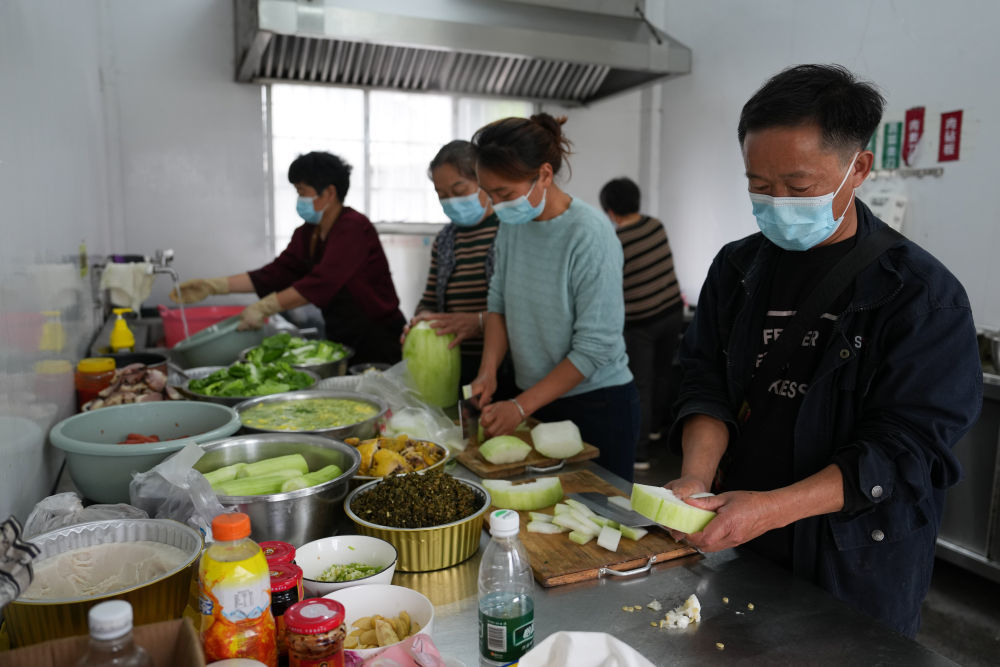 5月23日,工作人员在石门县壶瓶山镇鼓锣坪村安置点准备午饭。新华社记者 陈振海 摄