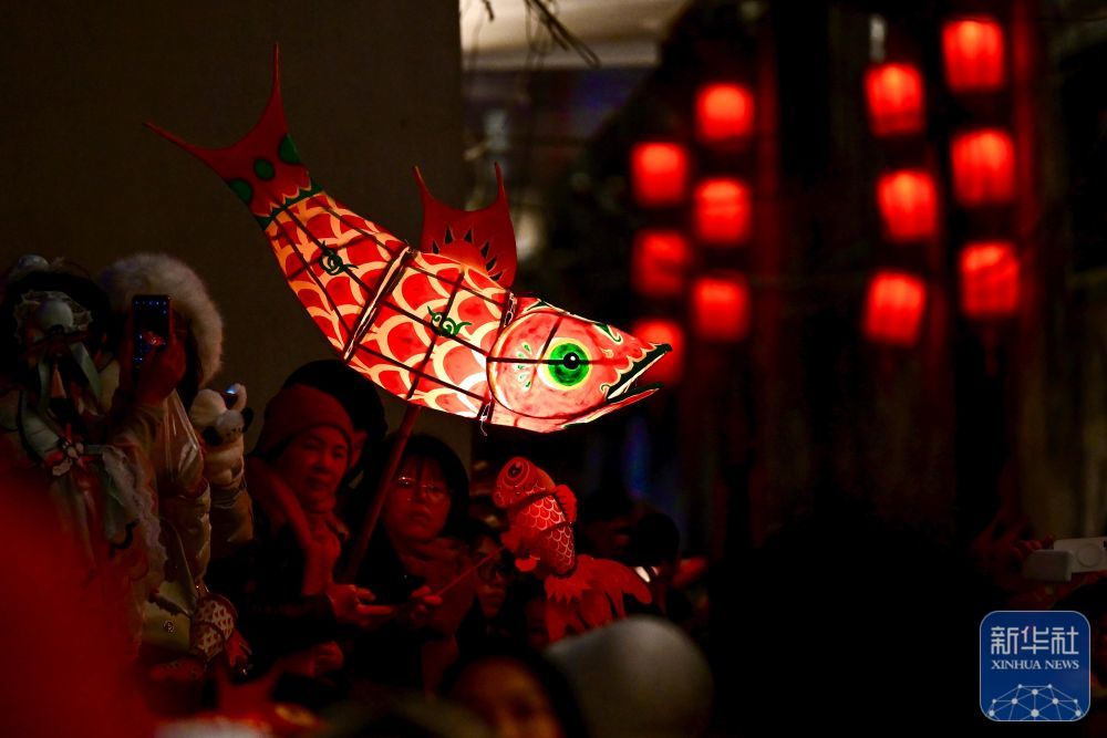 2月7日,游客在瞻淇村等待鱼灯表演。