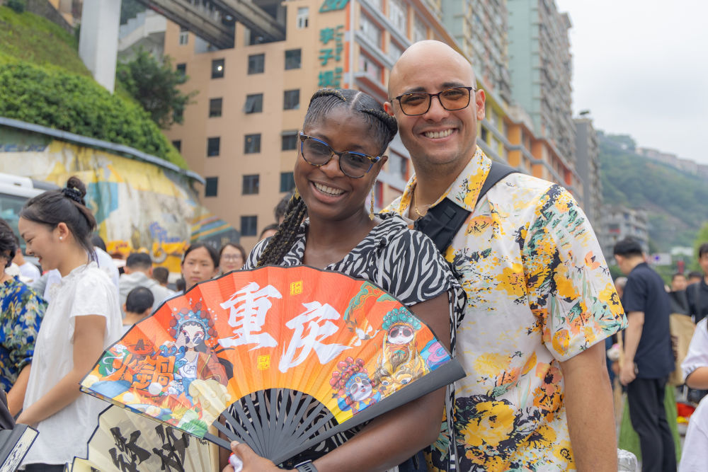 2025年10月3日，加拿大游客克里斯提安（左）和家人在重庆市渝中区李子坝游玩。近年来，不断优化的入境政策为境外游客赴华提供了更多便利，“来华旅游攻略”“赴华购物清单”等成为国外社交媒体热门搜索关键词，“China Travel”的热度延续至今。山城重庆凭借其独特的城市景观和风土人情，吸引不少外国游客前来品尝美食、打卡景点、体验文化。