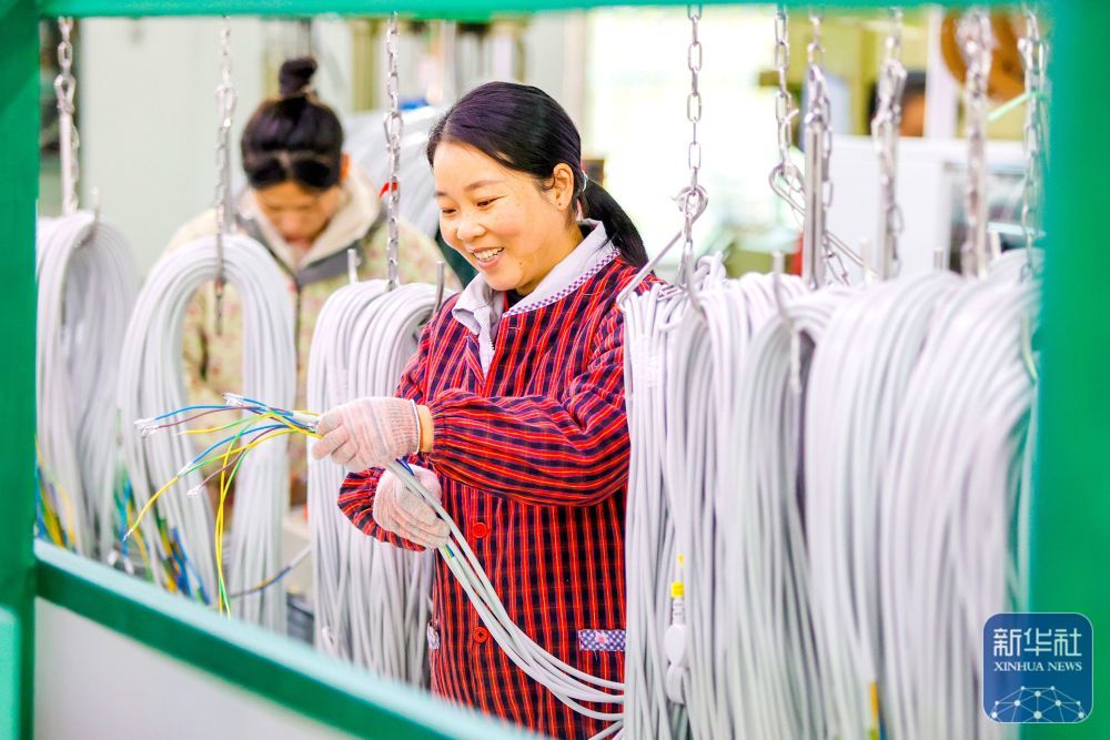 ↑ 1月2日,工人在江西省吉安市峡江县一家企业的生产车间内加工电线电缆。新华社发(陈福平摄)