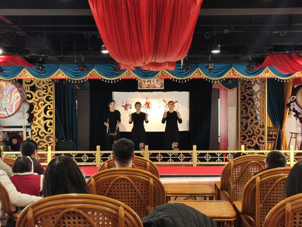 三位演出者正在向台下观众展示表演时用到的皮影。新华社记者 张申博 摄