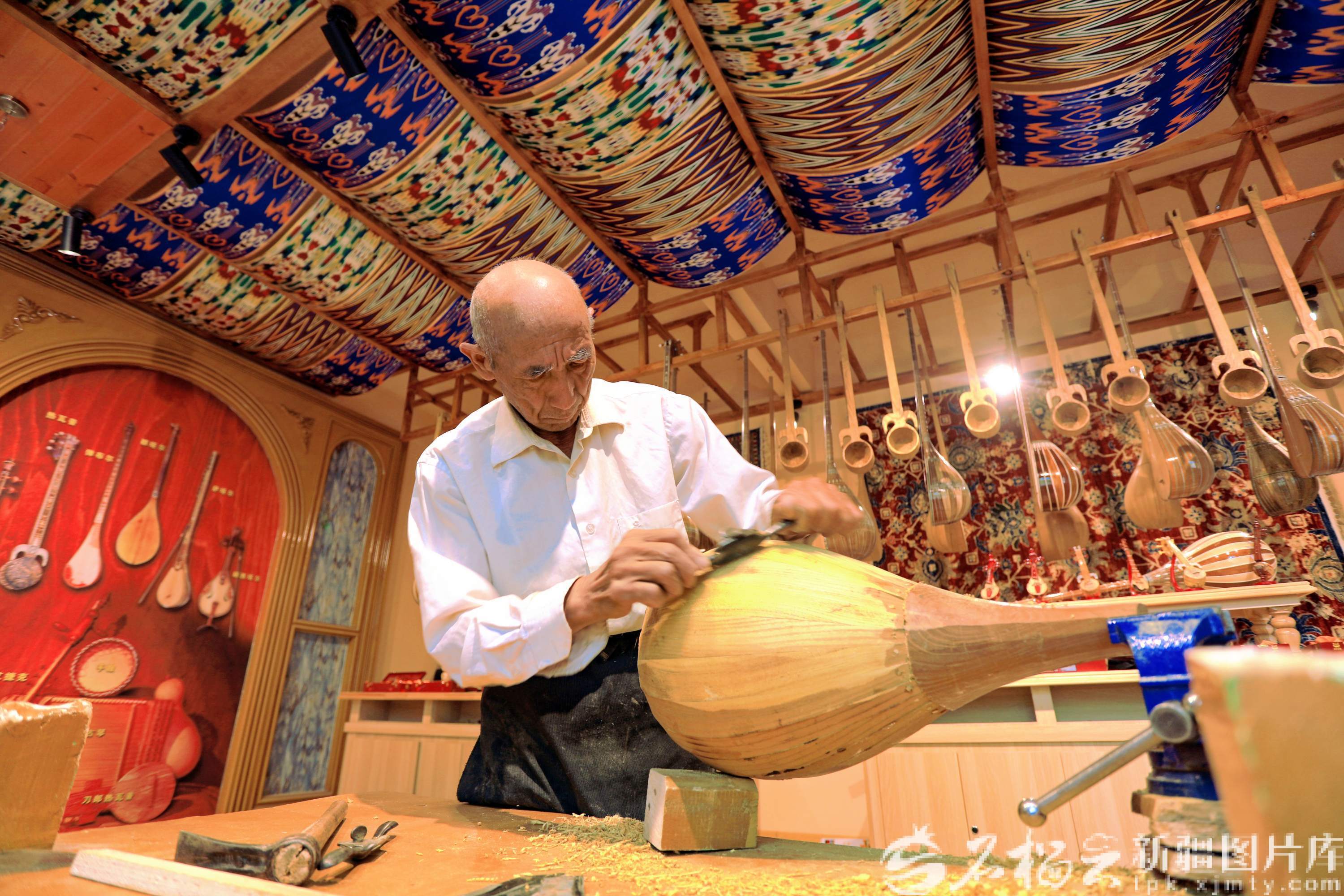 2026年1月3日，村民在托万克吾库萨克村民族乐器手工坊内打磨乐器。米尔阿迪力江&middot;麦麦提吐尔逊摄