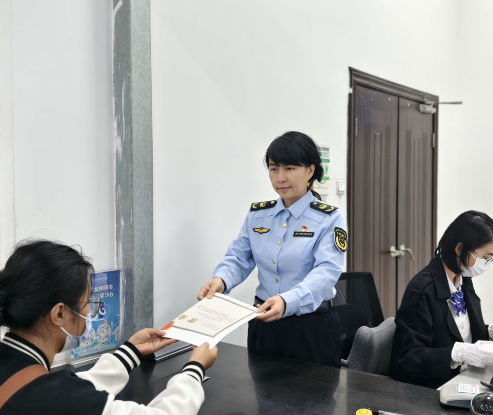 2026年2月6日，广州白云区市场监管局副局长孔丽雅（中）在帮助市民办理营业执照。（受访者供图）