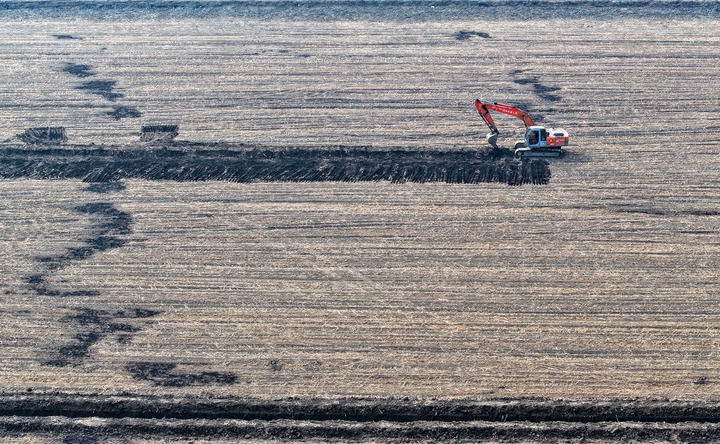 2025年3月11日，在天津市津南区八里台镇大韩庄村，工人驾驶挖掘机进行高标准农田施工作业（无人机照片）。新华社记者 赵子硕 摄