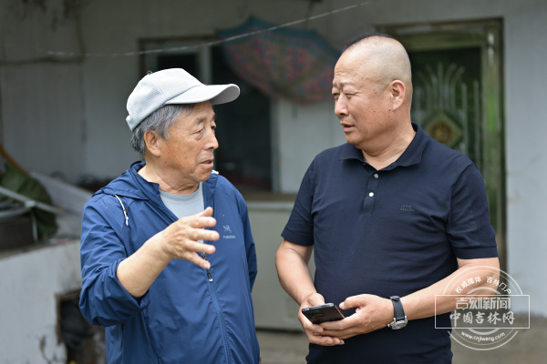 志愿者顾万祥(左)与烈士李日善之孙李光(右)