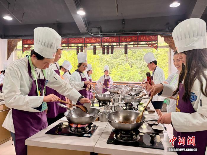 7月9日,四川成都,第三期美国华裔青少年“巴蜀文化品悟之旅”营员学做宫保鸡丁。王利文 摄