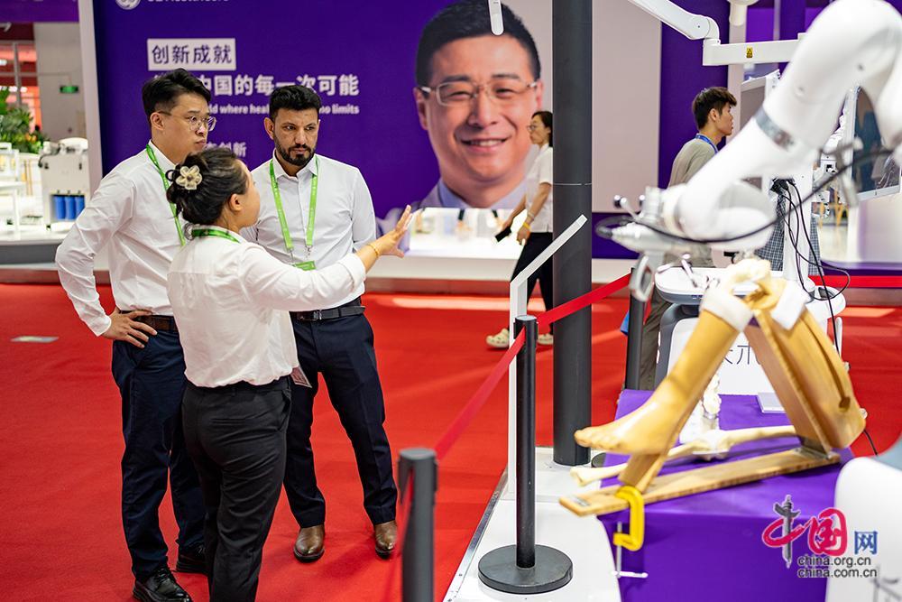 长木谷工作人员向来自德国（右1）的观众介绍全球首展的六位一体ROPA6人工智能全骨科手术机器人，其核心部件实现了国产化。中国网记者 郑亮摄
