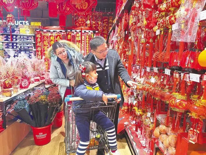 Madelief和丈夫带着女儿选购新年饰品。 （湖北日报全媒记者 汪蕾 摄）