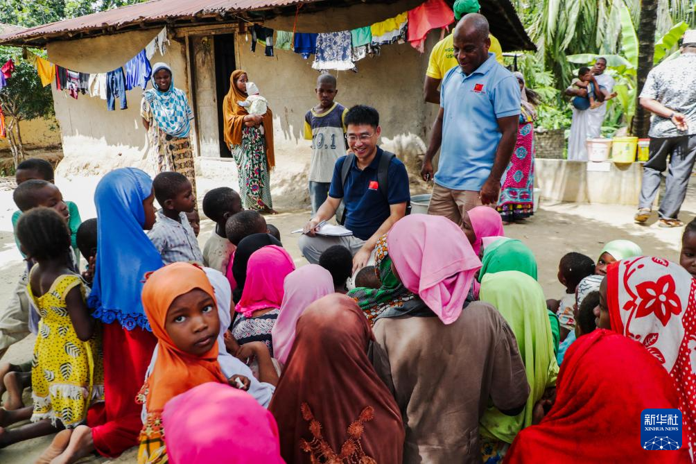 1月1日,在坦桑尼亚桑给巴尔的奔巴岛,中国援助坦桑尼亚“桑给巴尔血吸虫病防治技术项目”专家组队长汪伟(中)与当地儿童交流,开展健康宣教。新华社发(赫尔曼·埃马纽埃尔摄)