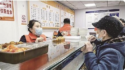 餐厅工作人员给老人选好的菜品装盒。