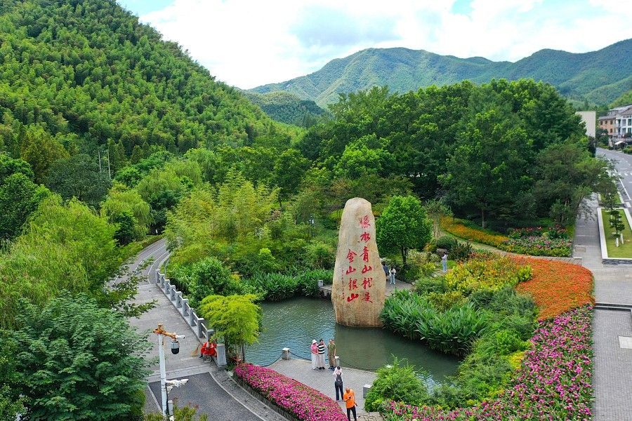 2025年8月6日,在浙江省湖州市安吉县余村,游客在刻有“绿水青山就是金山银山”的石碑前留影。新华社记者 毛竹 摄