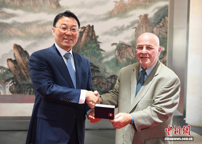 2026年6月19日，华盛顿，中国驻美大使谢锋代表中国有关方面邀请“赛考斯”再次访华，并向他颁发签证。中新社记者 陈孟统 摄