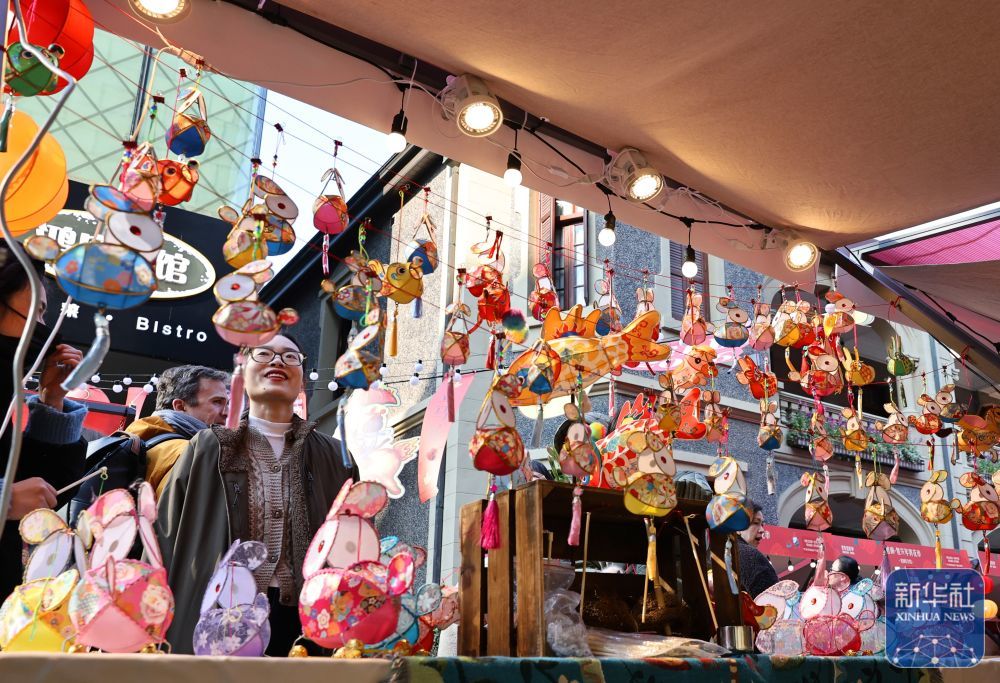 ↑1月23日，上海思南年宵花市上的传统彩灯手工艺品吸引游客驻足观看。新华社记者 方喆 摄