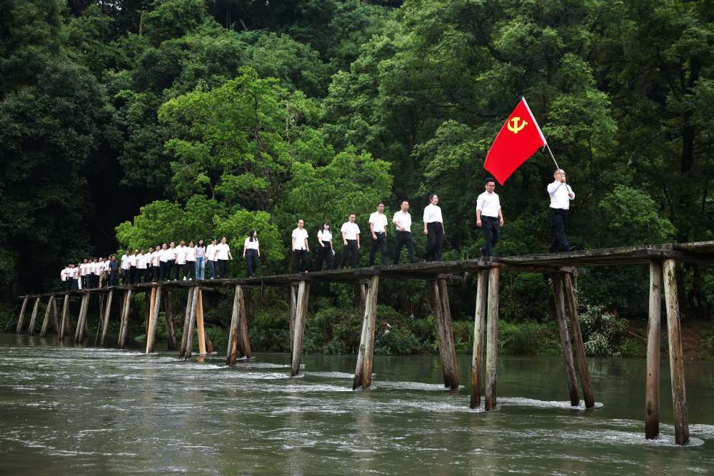 2026年7月1日,贵州省黔东南苗族侗族自治州黎平县高屯街道参加“重走长征路”活动的干部职工从修整后的红军桥上经过。新华社记者 杨文斌 摄