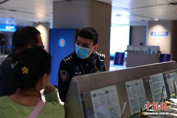 哈尔滨出入境边防检查站移民管理警察为入境旅客讲解240小时过境免签政策。　陈尚楠 摄