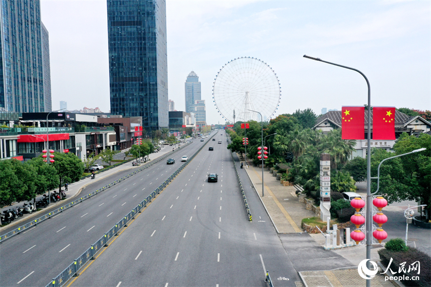 南昌市红谷滩区的道路两侧悬挂着崭新的国旗，城市洋溢着喜庆祥和的节日氛围。人民网记者 时雨摄