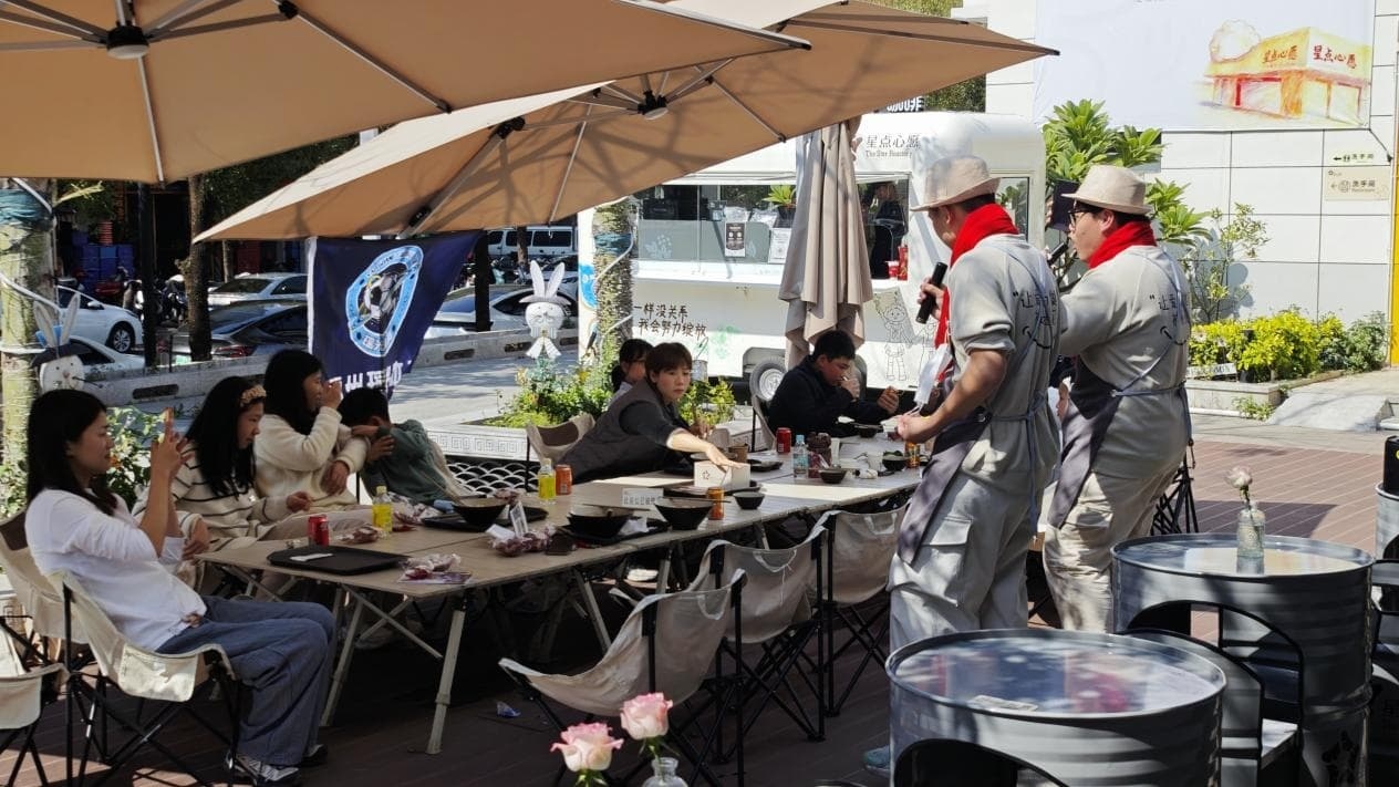 旺旺仔（左）和嘉禾（右）给团建的足球队唱歌（记者江晓晨 摄）