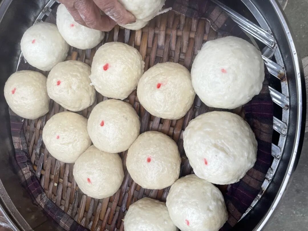 爷爷奶奶亲手包的馒头,每个馒头上还会点一个红点。(图/钱雨朦 摄)