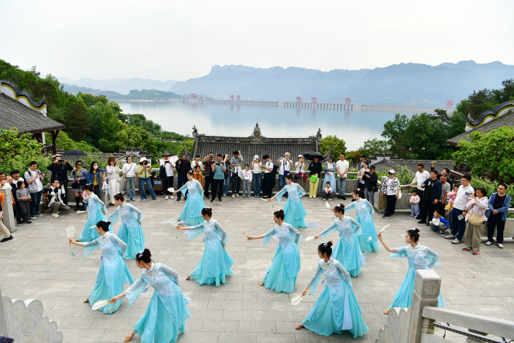 ↑ 5月3日，游客在三峡大坝附近的湖北省宜昌市秭归县屈原故里文化旅游区观看文艺表演。新华社发（王辉富摄）
