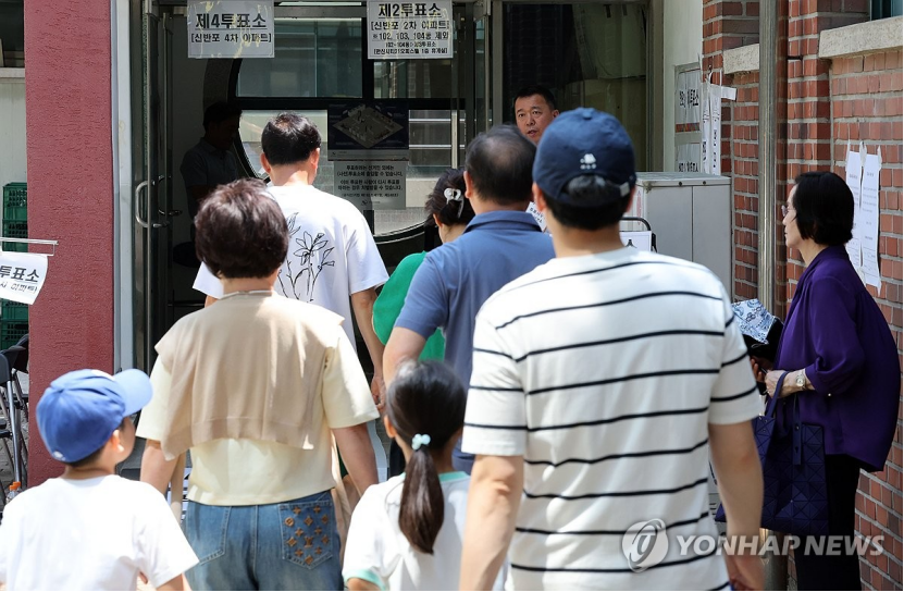 △6月3日，首尔瑞草区盘元小学投票所，一家人准备入场投票。（图源：韩联社）