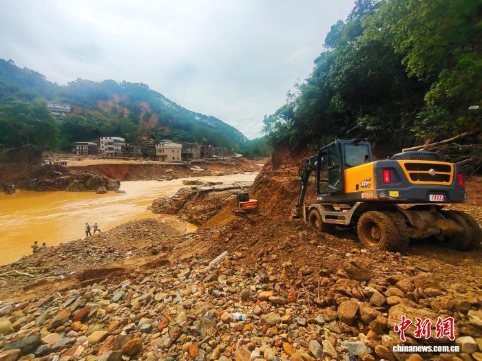 7月9日,在广西南宁横州市镇龙乡凤丹村,挖掘机在进行道路抢通作业。 中新社记者 黄艳梅 摄