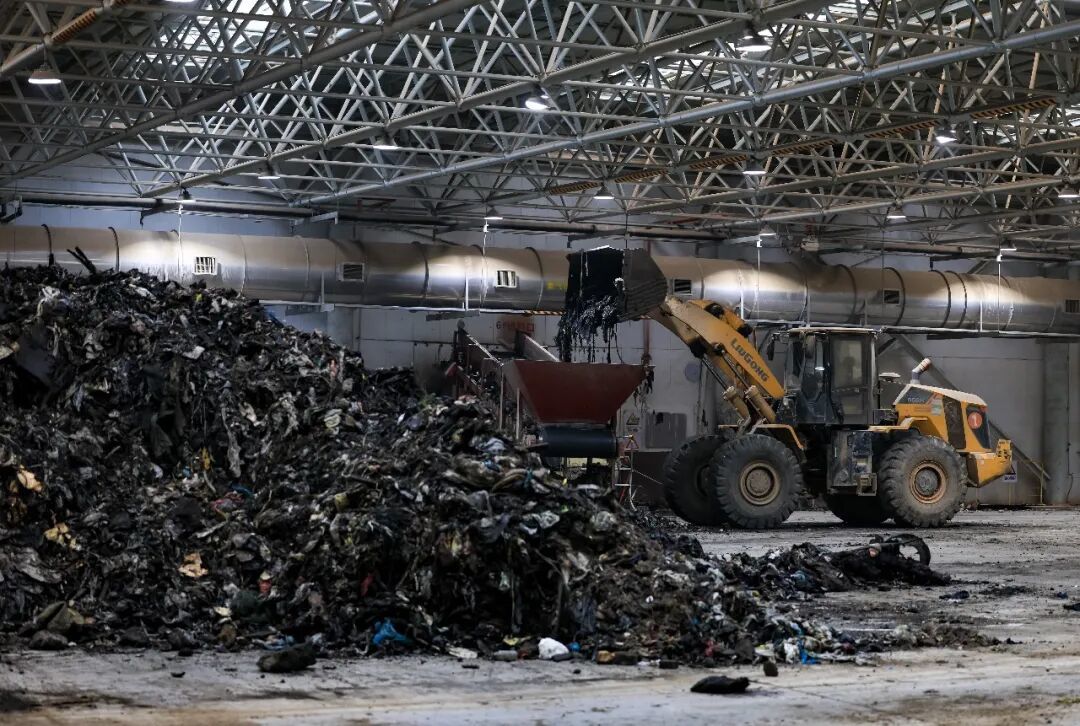 2025年12月25日,工程车在晾晒车间进行垃圾搬运工作/新华社记者 毛思倩 摄