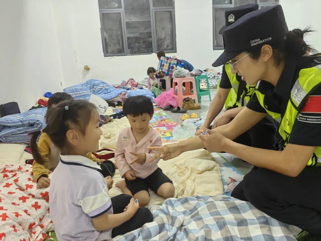 转移安置点内，独龙江边境派出所民（辅）警俯身关切，为受灾群众送上陪伴与守护。