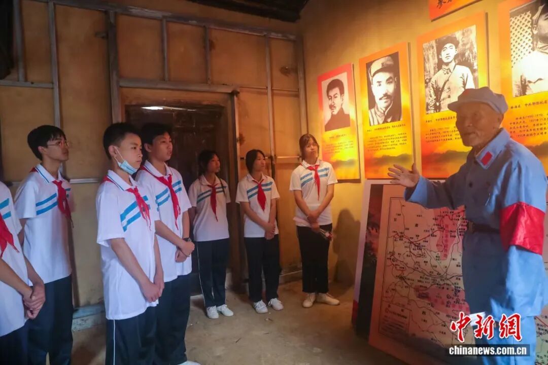 图为王茂贵老人为研学青少年讲解。光山县委宣传部供图