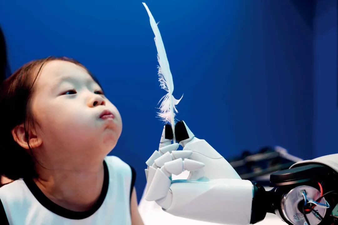 8月21日,2026世界机器人大会期间,小观众感受灵巧手的超轻微风力精细感知。摄影/本刊记者 王紫儒