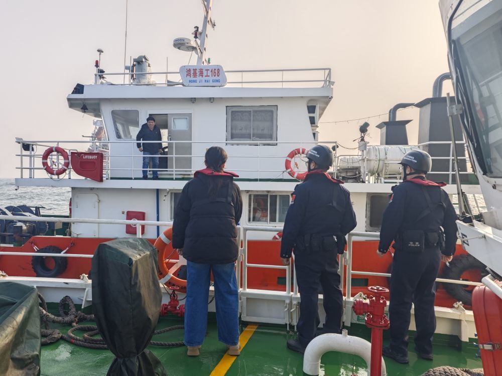 民警检查船只的搭靠外轮许可证。新华社记者董笑坤 摄