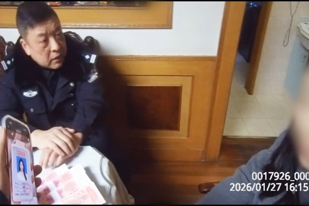 民警向周女士讲解相关案例,指出对方工作证件中的伪造痕迹。 上海市公安局 供图