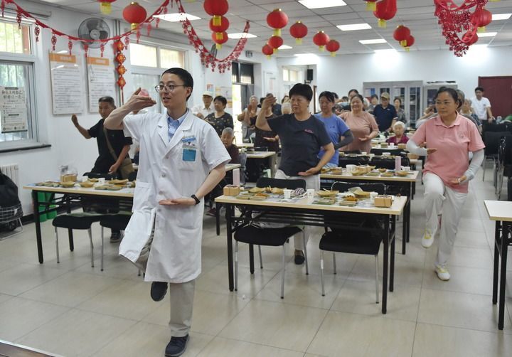 在北京市丰台区西罗园第一社区新时代文明实践站,西罗园社区卫生服务中心中医康复科医生田正强带领社区居民练习五行掌(2026年7月15日摄)。新华社记者 赵婷婷 摄