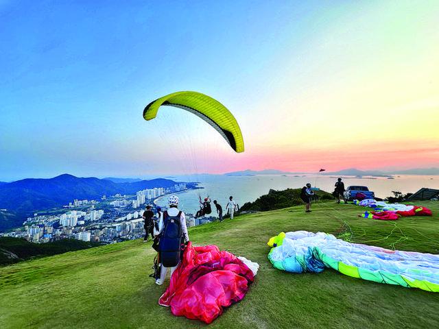 10月1日,游客在惠东县巽寮湾体验滑翔伞项目。 惠州日报记者谭琳 通讯员陈慧 摄