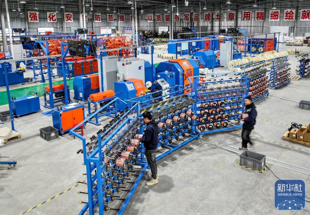 ↑ 2月24日,在四川省华蓥市华蓥山经开区拓自达电线(四川)有限公司智能车间,工人利用机械设备生产订单产品(无人机照片)。新华社发(邱海鹰摄)