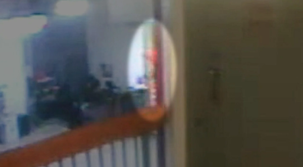 被放大的监控画面显示,通往爱泼斯坦囚室所在监区的楼梯上,出现一个橙色物体的局部影像。 视频截图