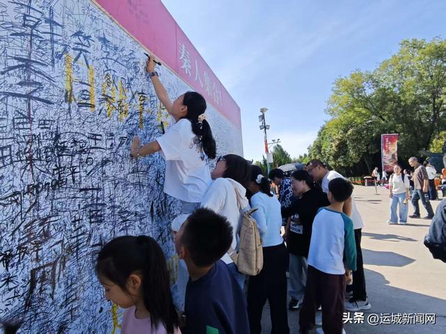 图为签名墙前游人如织 记者 荆毅萍 摄