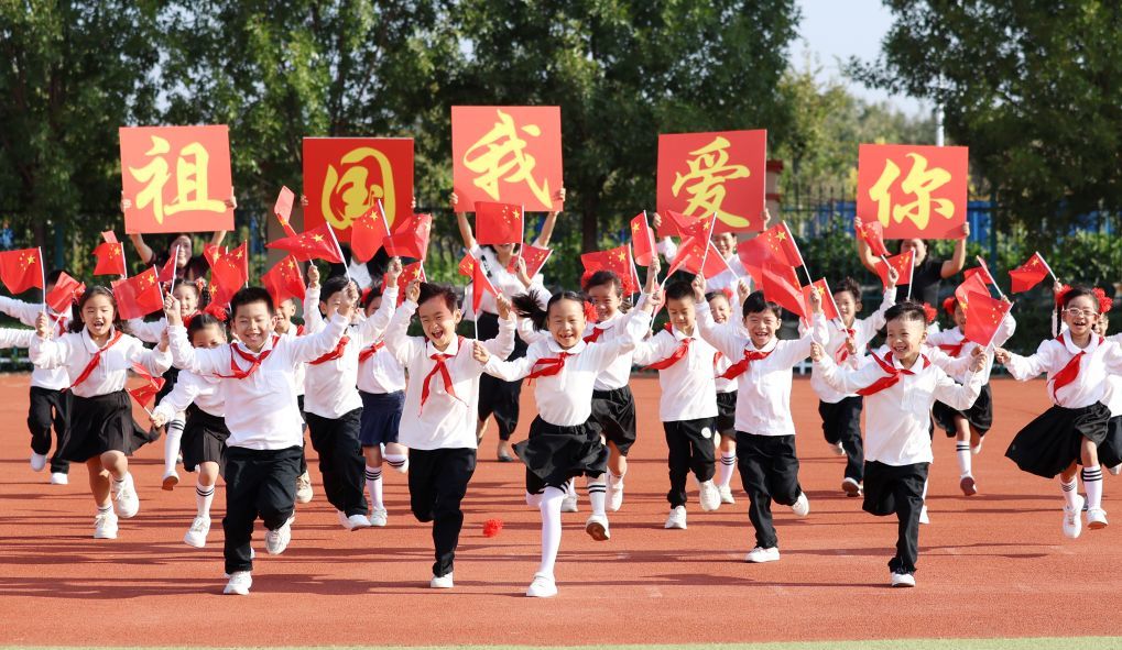 2024年9月29日,山东省临沂市郯城县第一实验小学学生手持国旗快乐奔跑,喜迎国庆节的到来。新华社发(张春雷摄)