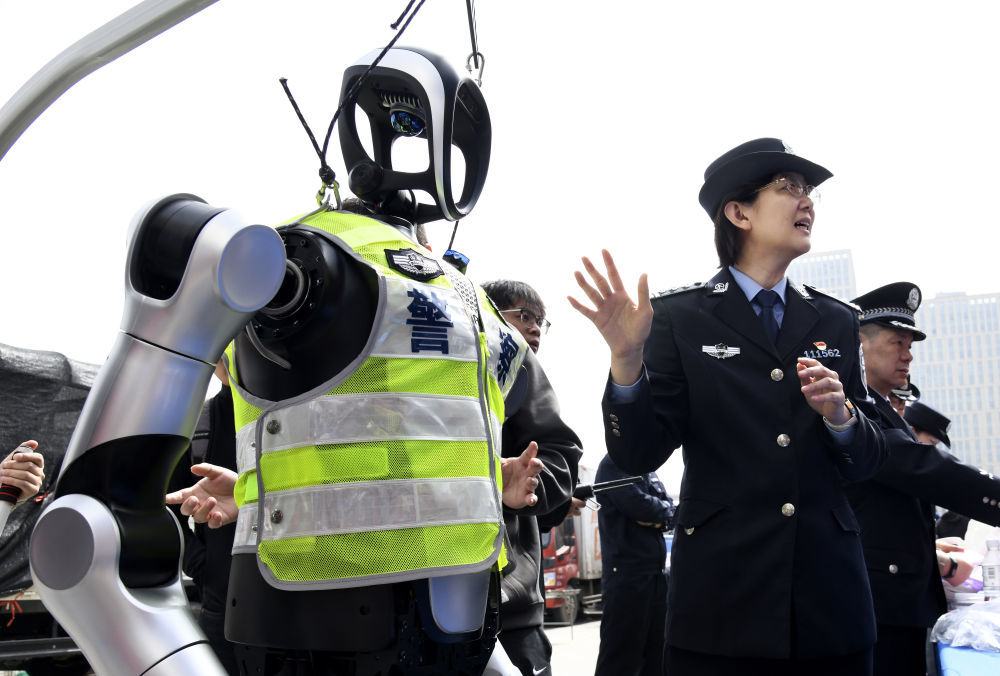 2025年3月24日，在青岛市流动人口服务管理宣传周活动中，民警向群众介绍警用机器人。新华社记者 李紫恒 摄