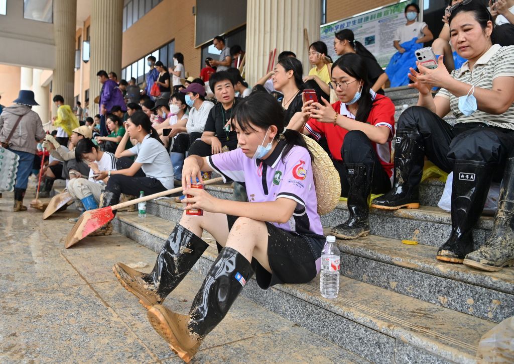 7月15日，人们在广西贵港市高级中学清淤间隙休息。新华社记者 陆波岸 摄