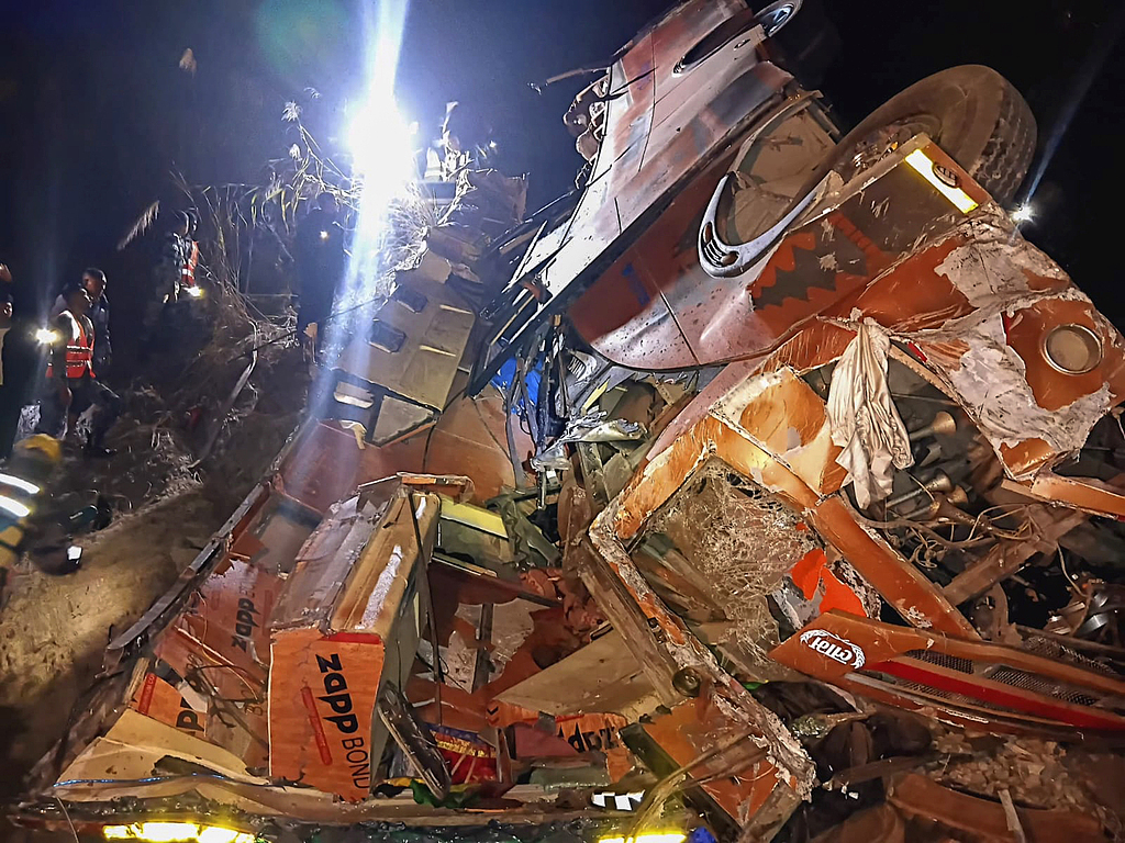 尼泊尔武装警察部队的救援人员在巴士事故现场搜救遇难者遗体和伤者。