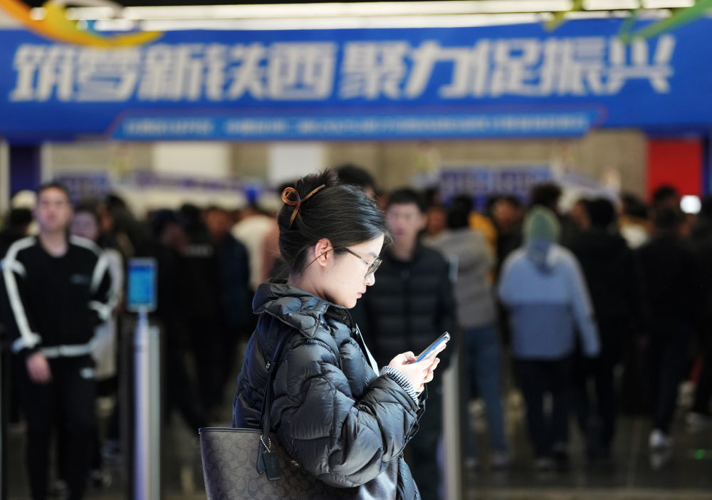 在沈阳的全球工业互联网大会会议中心，一名应聘者在以“筑梦新铁西 聚力促振兴”为主题的现场招聘活动中查阅信息（2025年3月29日摄）。新华社记者 李钢 摄