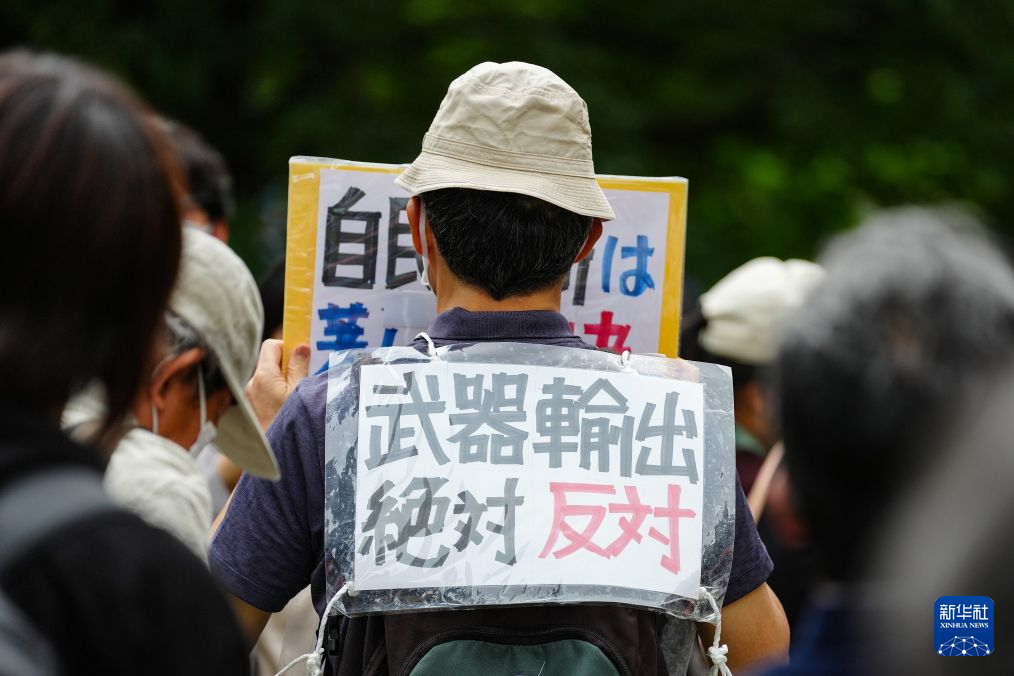 8月15日，在日本东京的淡路公园内，日本民众手持标语参加集会。新华社记者 贾浩成 摄